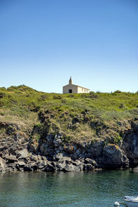 House by sea against clear sky