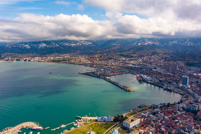 High angle view of cityscape by sea against sky