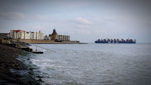 Scenic view of sea and cityscape against sky