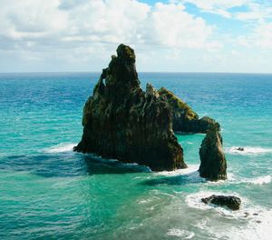 Scenic view of rocks in sea against sky