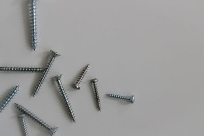 High angle view of screws against white background