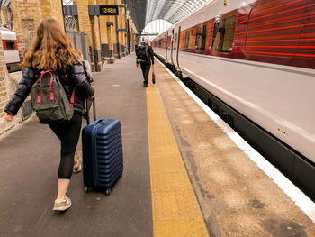 Rear view of woman on railroad station platform