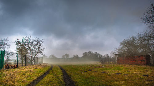 Scenic view of grassy field against cloudy sky