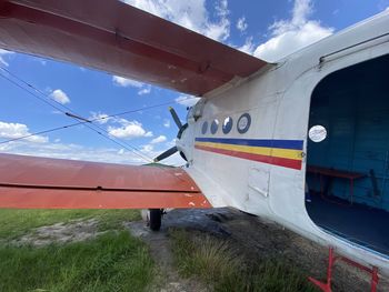 Airplane on airport runway against sky