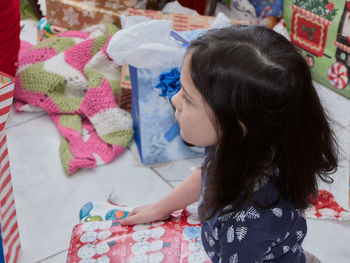 Young children opening christmas presents at home