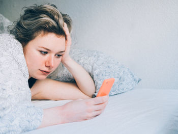 Woman in bed using phone