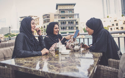 People sitting on table at cafe in city