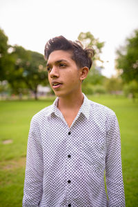 Portrait of young man standing on field