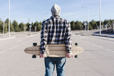 Close-up portrait of a man on his back holding the longboard