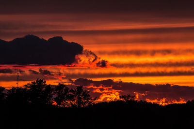 Silhouette of trees against dramatic sky