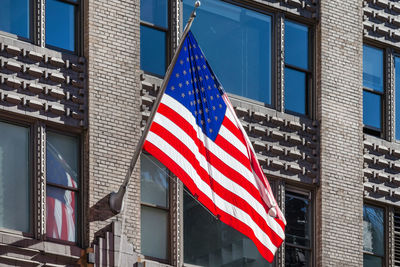 Low angle view of flag against buildings in city