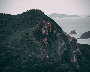 Scenic view of mountain and sea against clear sky