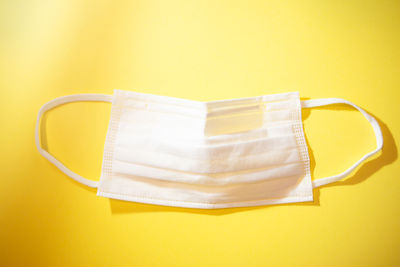 High angle view of papers on table against yellow background