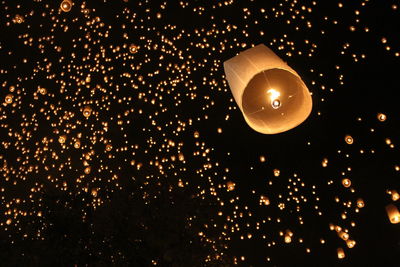 Low angle view of paper lanterns flying in mid-air at night