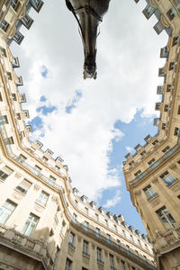 Low angle view of building against cloudy sky