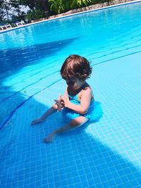 High angle view of baby girl sitting in swimming pool