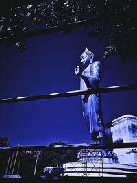 Low angle view of statue against blue sky