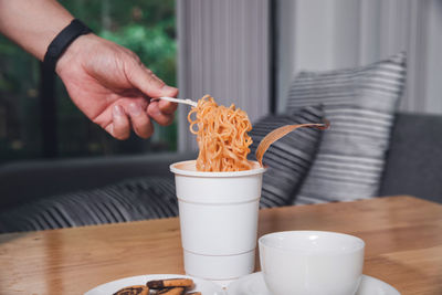 Midsection of person having breakfast on table