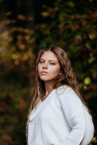 Young women in white sweater standing and looking