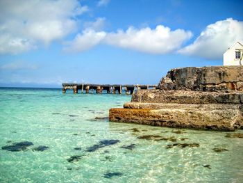 Scenic view of pier over sea against cloudy sky