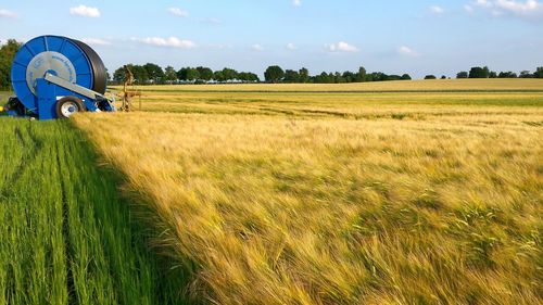 Scenic view of grassy field against cloudy sky