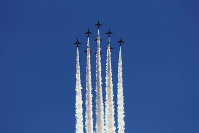 Low angle view of airplane flying against blue sky