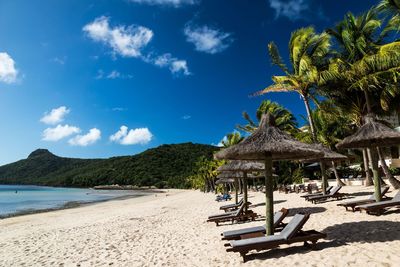 Scenic view of beach against cloudy sky