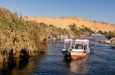 Close up view of colorful faluca traditional boat sailing in the river sorrounded by vegetation and