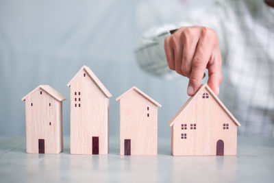 Hand holding toy against house in building