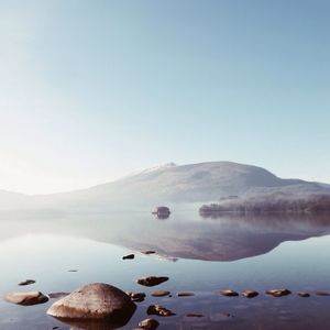 Idyllic view of lake by mountain against sky