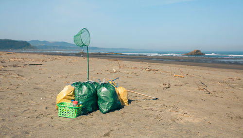 Container on beach against sky