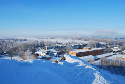 Aerial view of frozen landscape against blue sky