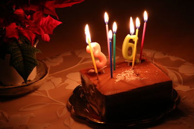 High angle view of illuminated birthday cake on table