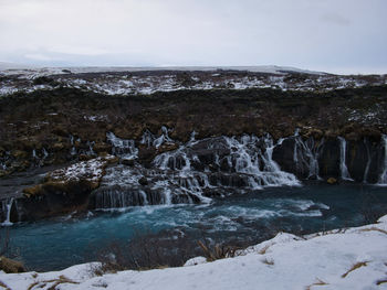 Scenic view of waterfall against sky