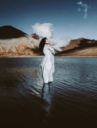 Rear view of woman standing in lake