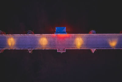 Directly above shot of illuminated pier over sea at night