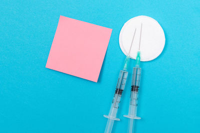 High angle view of paper on table against blue background