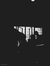 Silhouette people sitting in the dark room