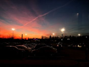 Illuminated city against sky during sunset