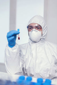 Portrait of female dentist holding dentures in laboratory