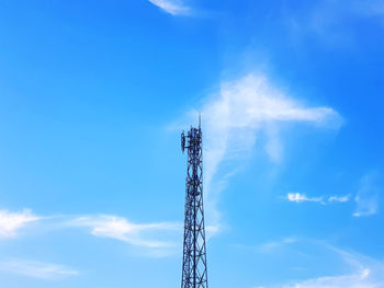 High section of telecommunication tower against blue cloudy sky