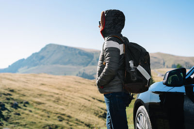 Rear view of man standing on mountain road