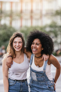 Happy female friends standing in city