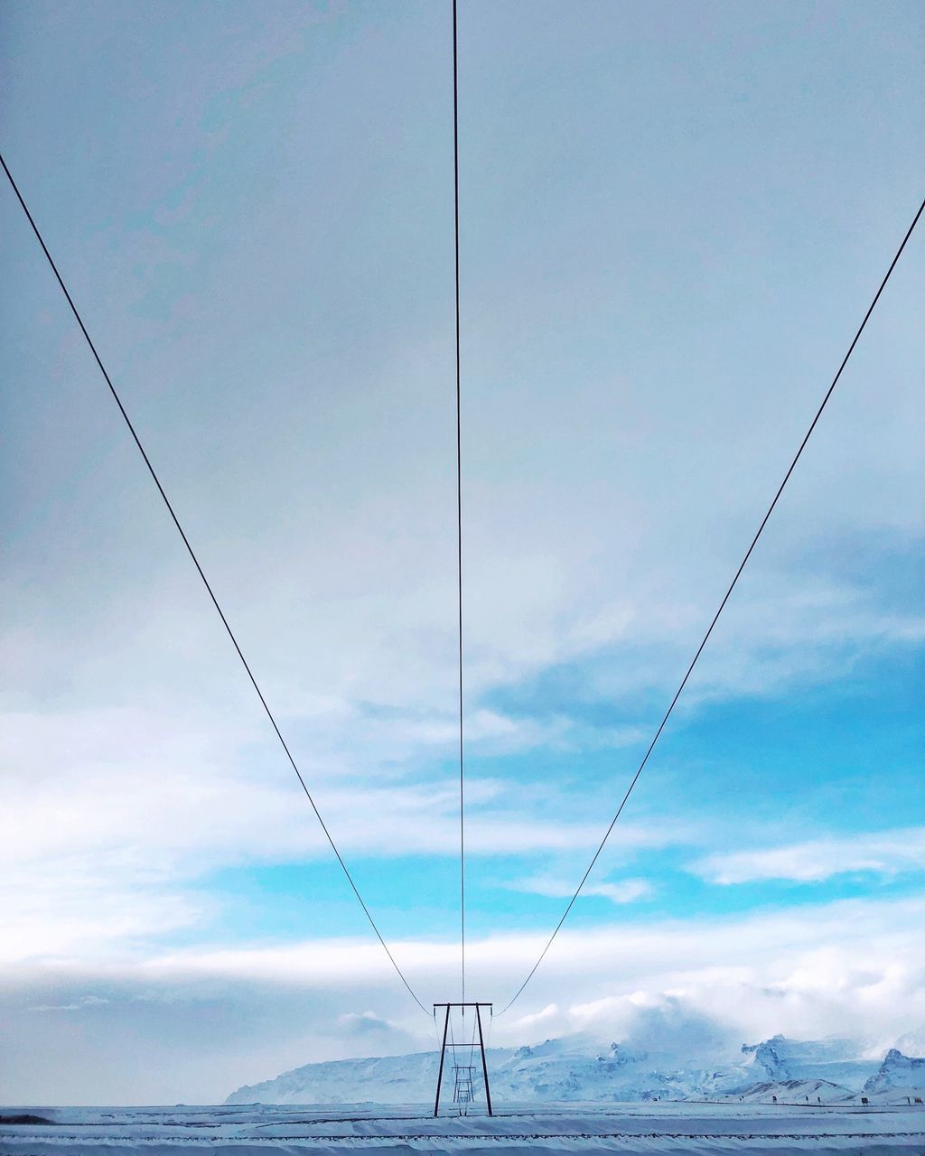 LOW ANGLE VIEW OF POWER CABLES AGAINST SKY