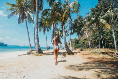 Rear view of woman walking at beach