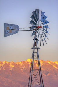 Windmill and mountain against clear sky