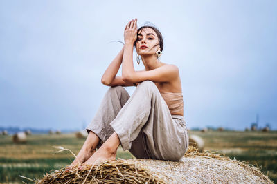 Midsection of woman sitting on field