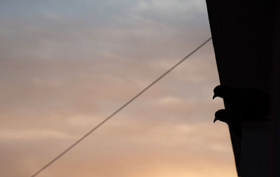 Low angle view of silhouette pole against sky at sunset