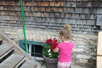 Rear view of girl standing against wall