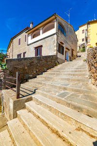 Staircase leading towards old building against blue sky